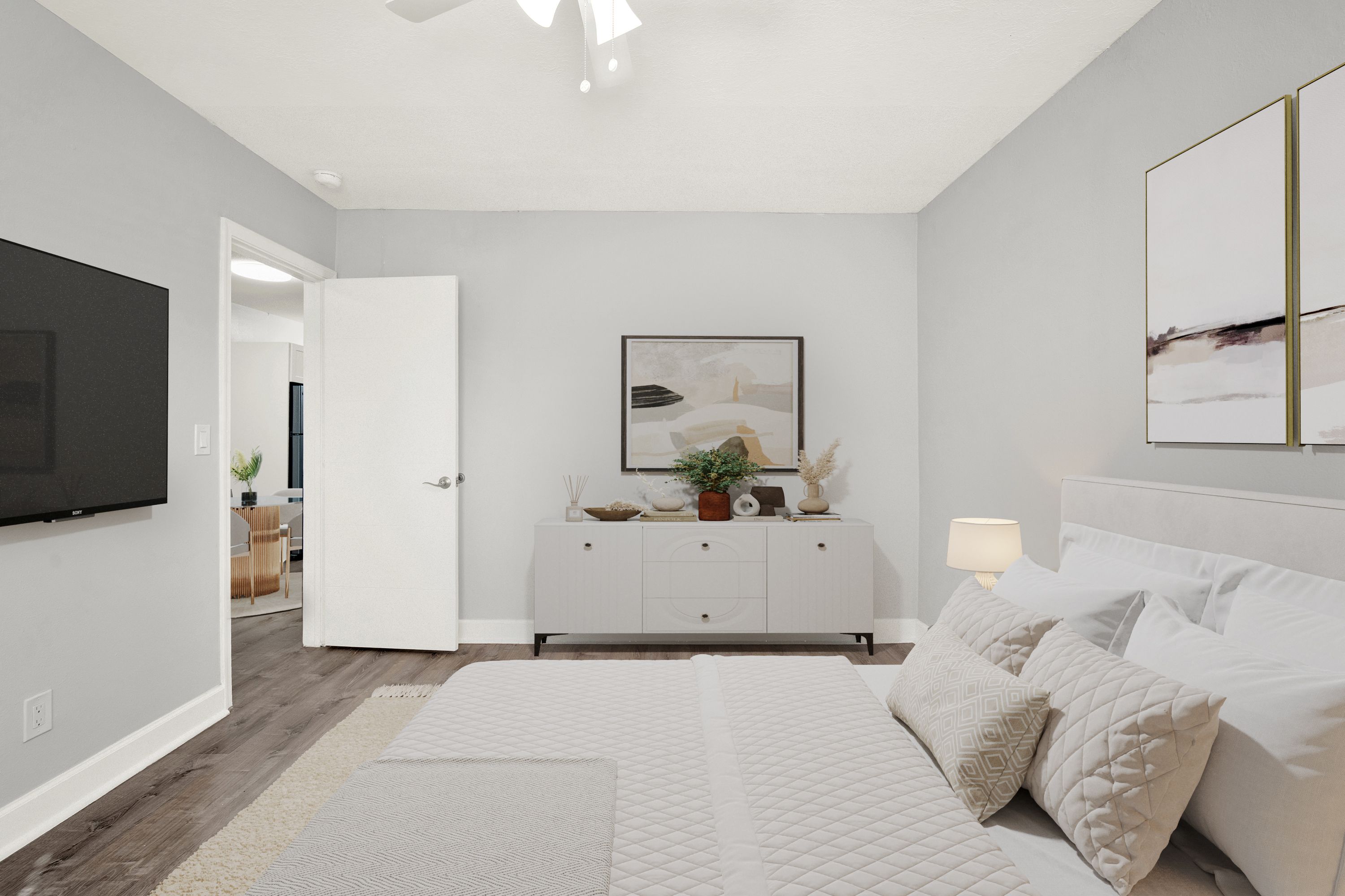 A bedroom with a bed, a dresser, and a television.