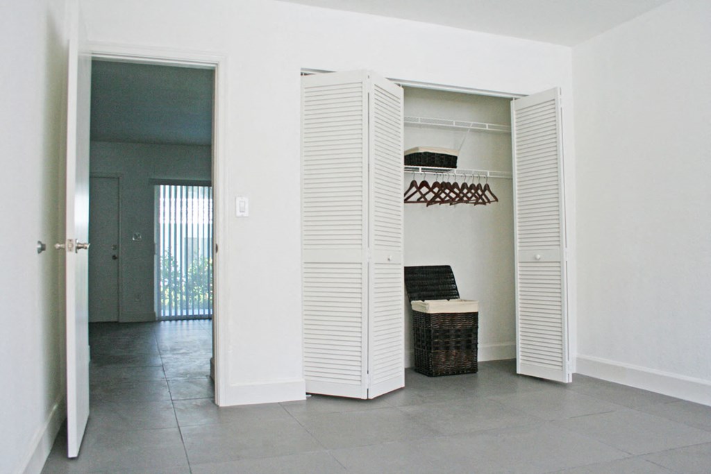 a closet with white shutters in a living room