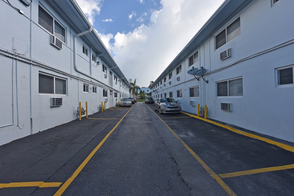 a large white building on the side of a street with parked cars
