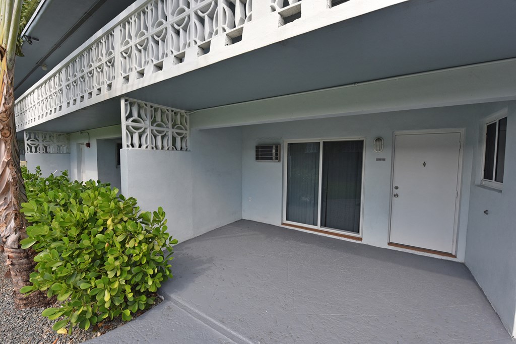 an outside view of a white building with a patio and a door