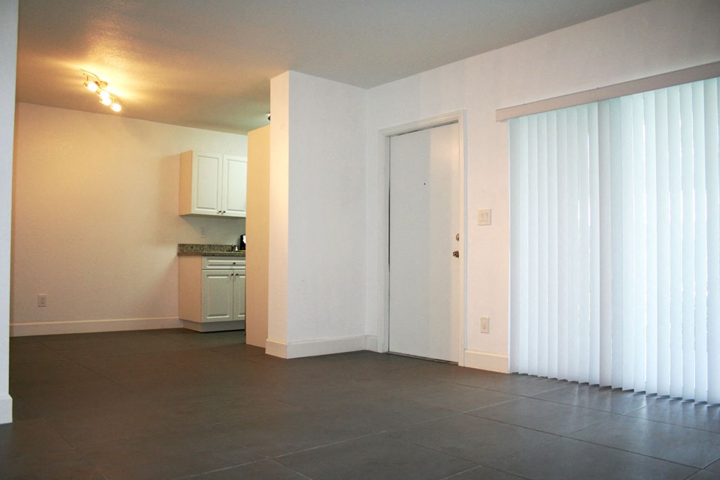 a view of a living room and a kitchen with a large window