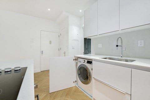 a kitchen with white cabinets and a washing machine in it