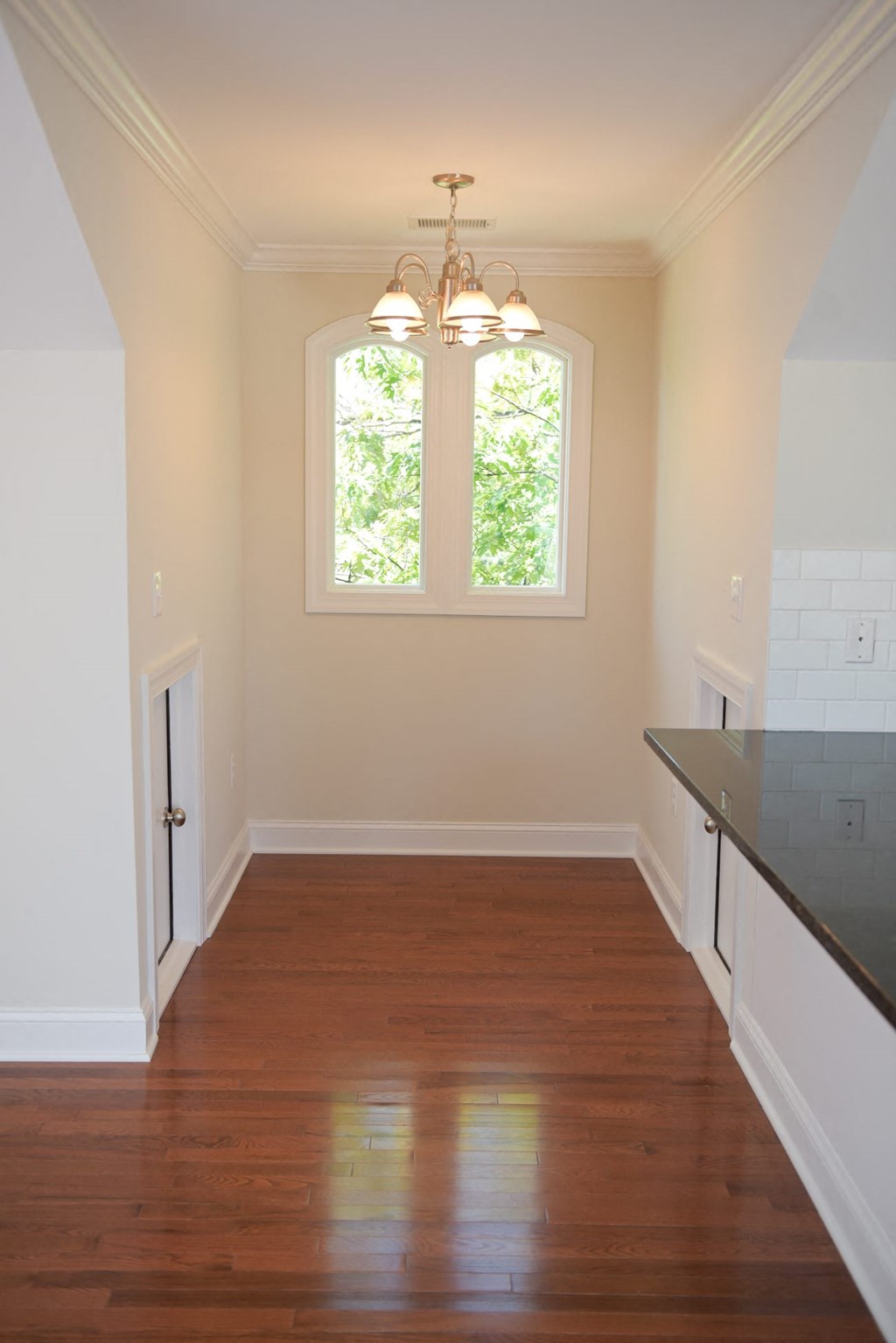 a kitchen with a hard wood floor and a window