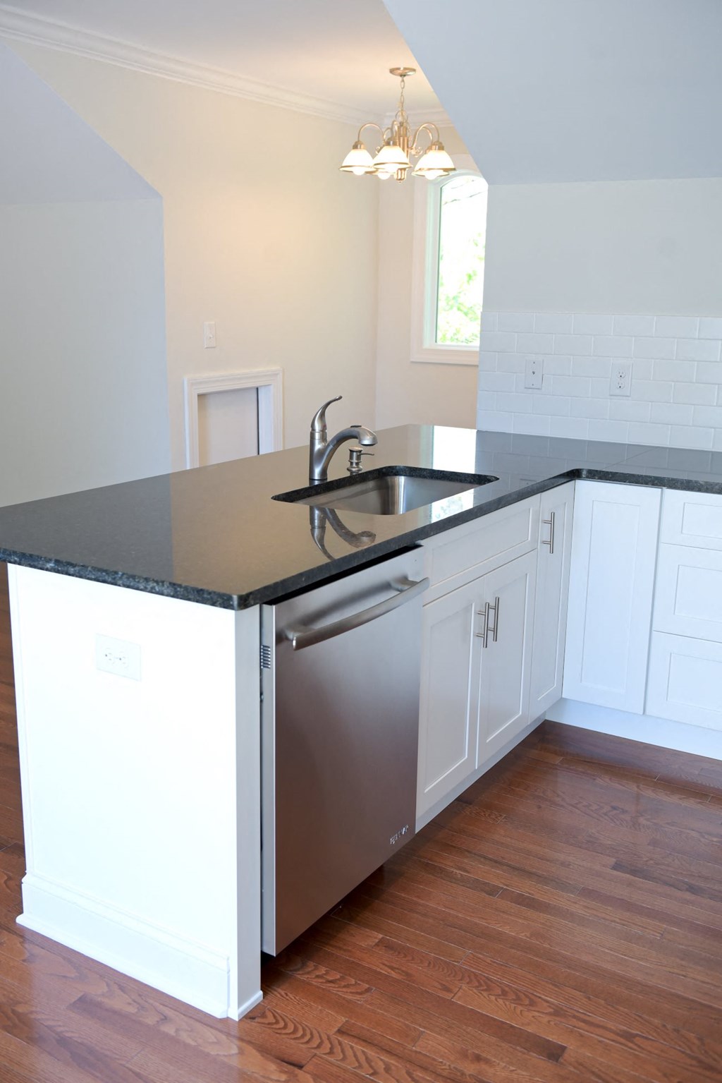 a kitchen with a stainless steel sink and white cabinets