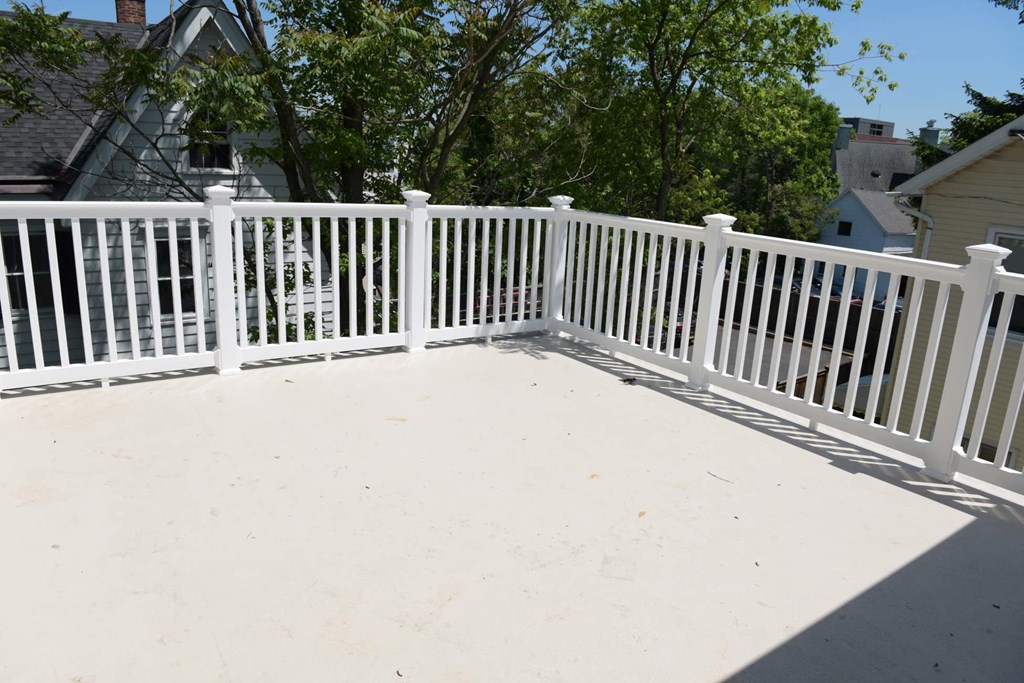 a white fence with a deck on top of it