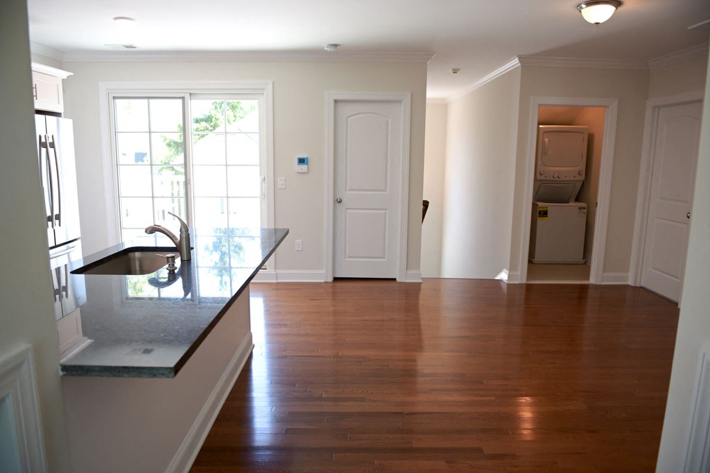 an empty kitchen and living room with hard wood flooring