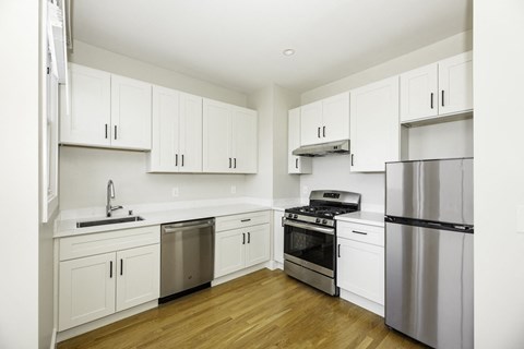 A kitchen with white cabinets and stainless steel appliances.