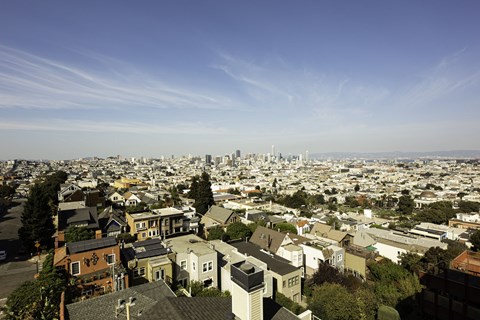A cityscape with a mix of residential and commercial buildings under a clear sky.