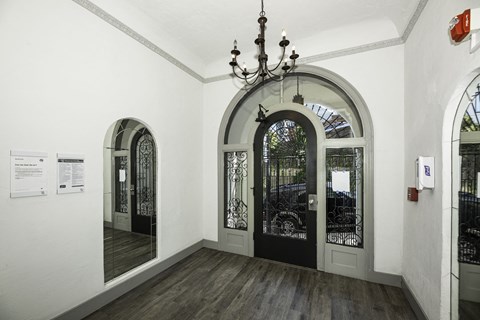 A hallway with arched doorways and a chandelier hanging from the ceiling.