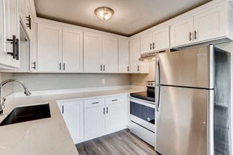 a kitchen with white cabinets and a stainless steel refrigerator
