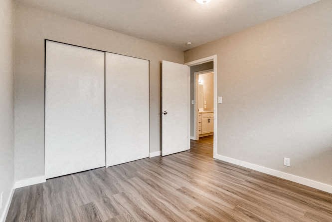 an empty living room with white walls and wooden floors