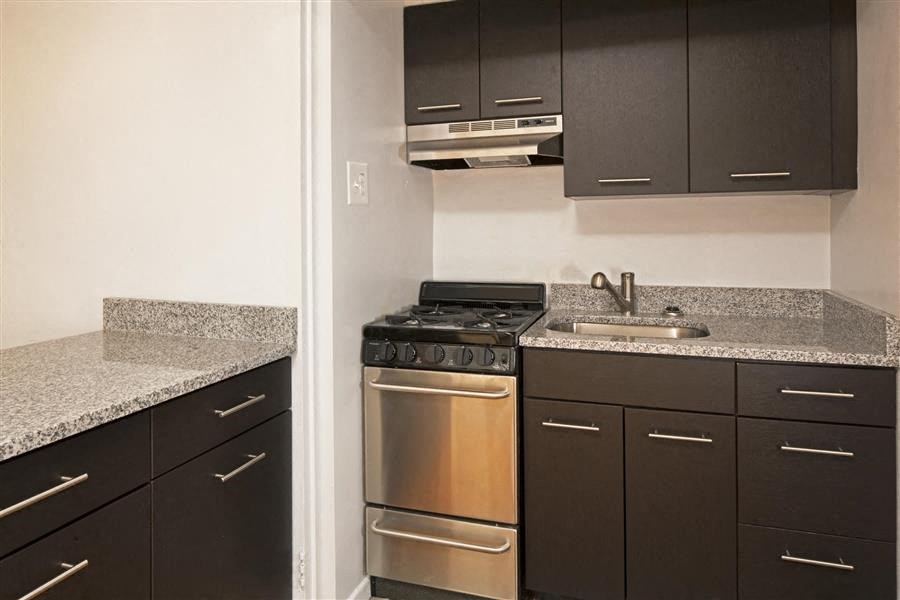 apartment kitchen with dark wood cabinets