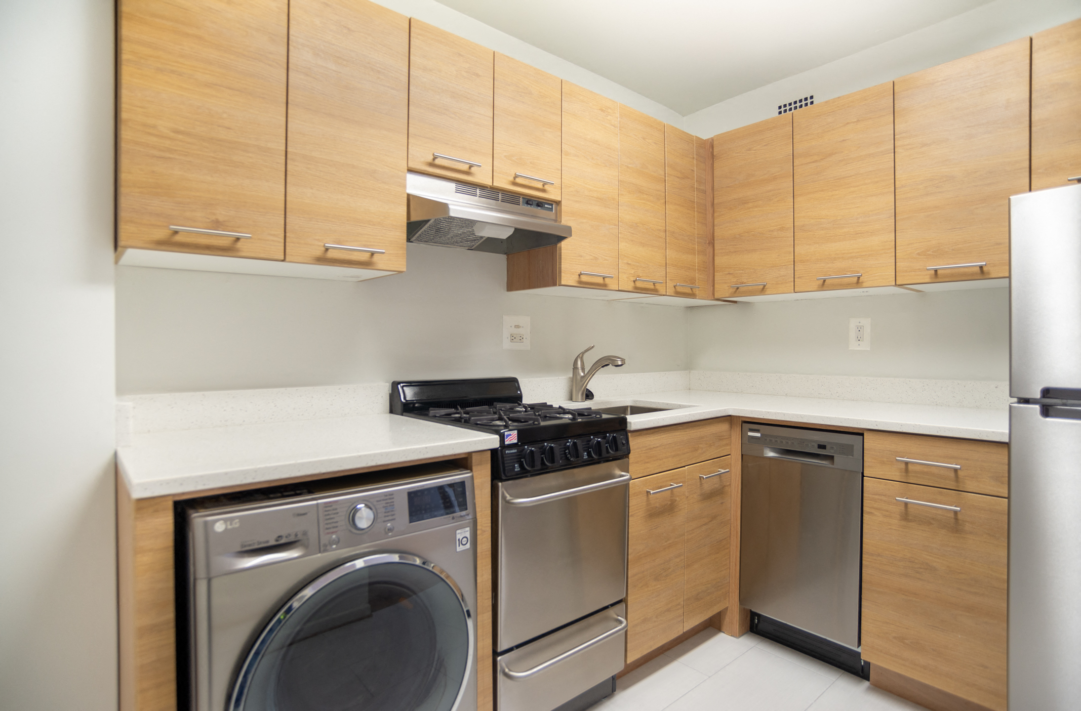 renovated apartment kitchen featuring a gas range stove, refrigerator, dishwasher, and washing machine