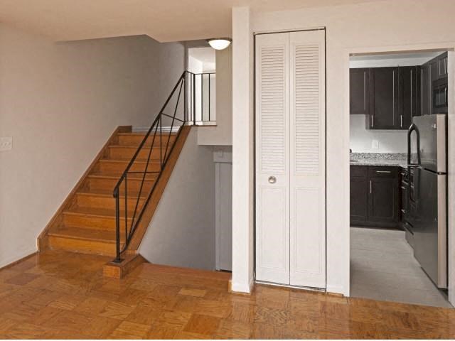 a room with a staircase and a kitchen and a door