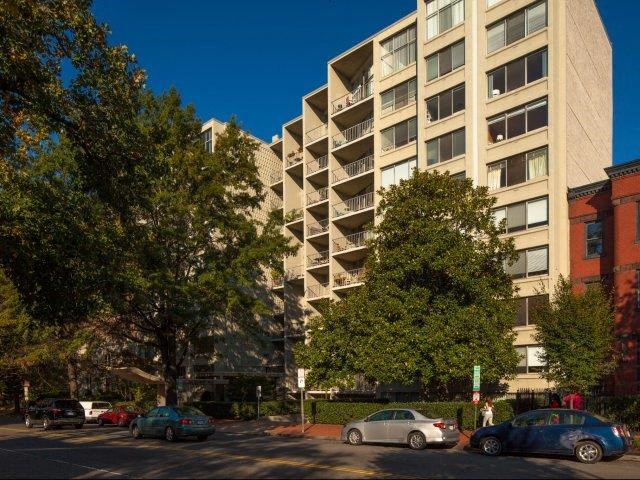 a large apartment building with cars parked in front of it