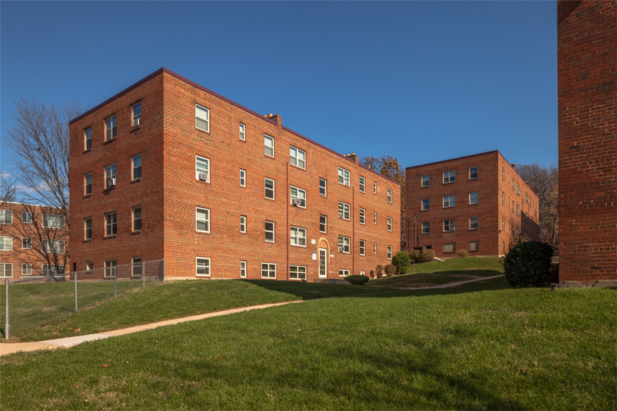 a large brick building on a hill with grass