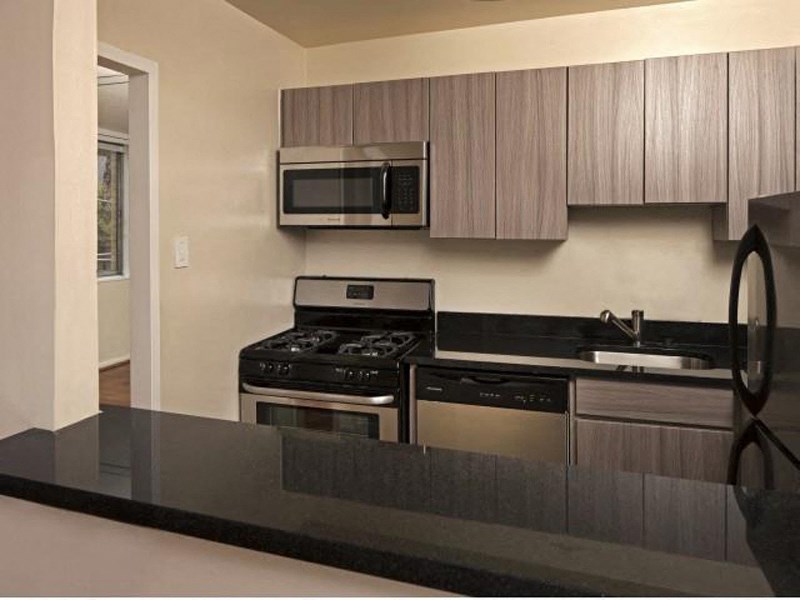 apartment kitchen with modern cabinets and stainless steel appliances