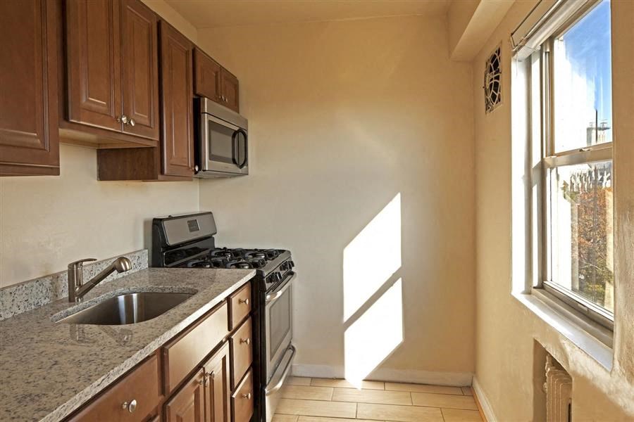 a kitchen with a sink and stove and a window