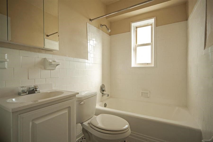 a bathroom with a toilet and a sink and a bath tub