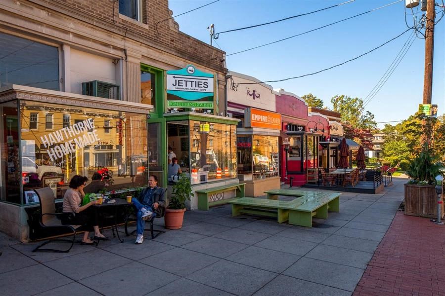 a group of people sitting at tables outside a restaurant