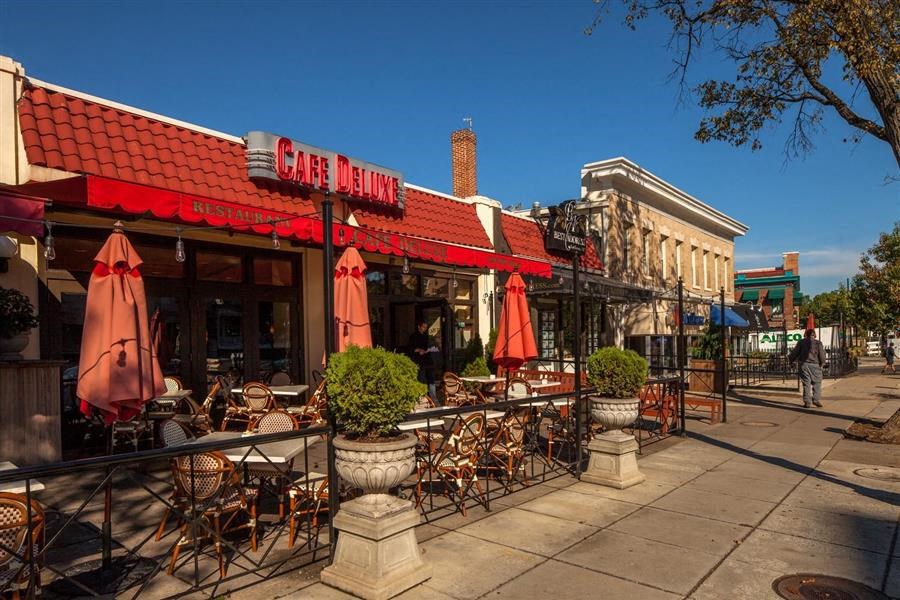 a restaurant with tables and chairs on the sidewalk