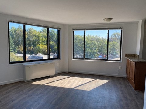 an empty living room with three large windows