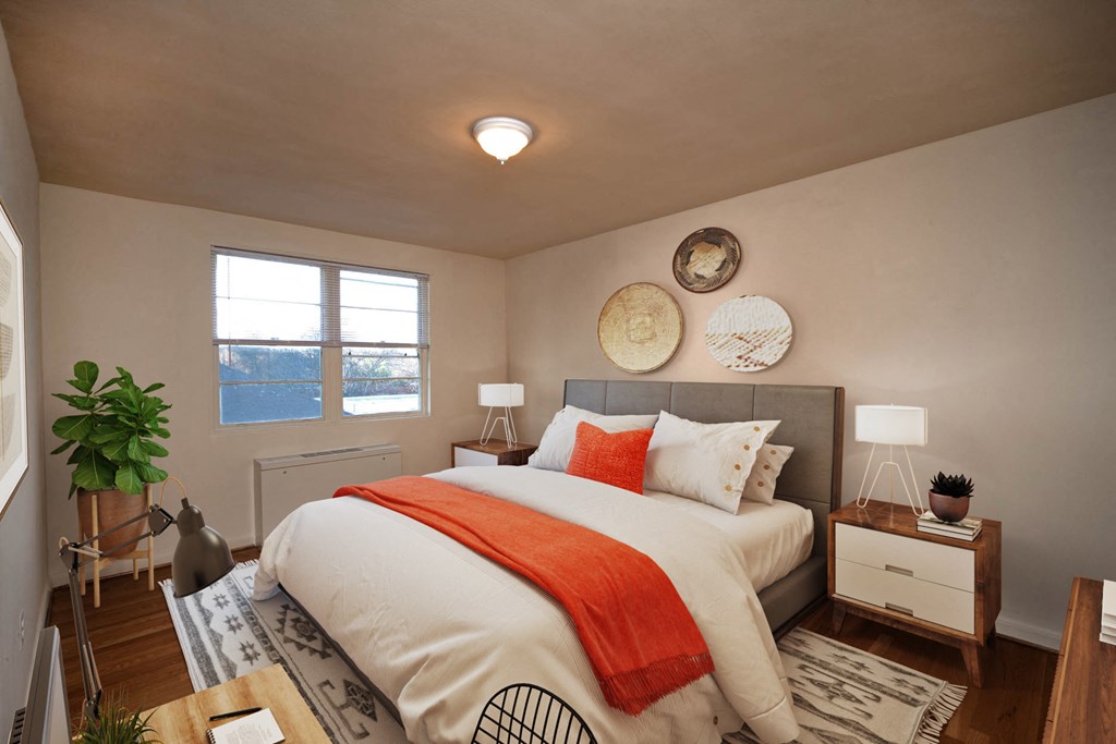 a bedroom with a white bed and an orange blanket