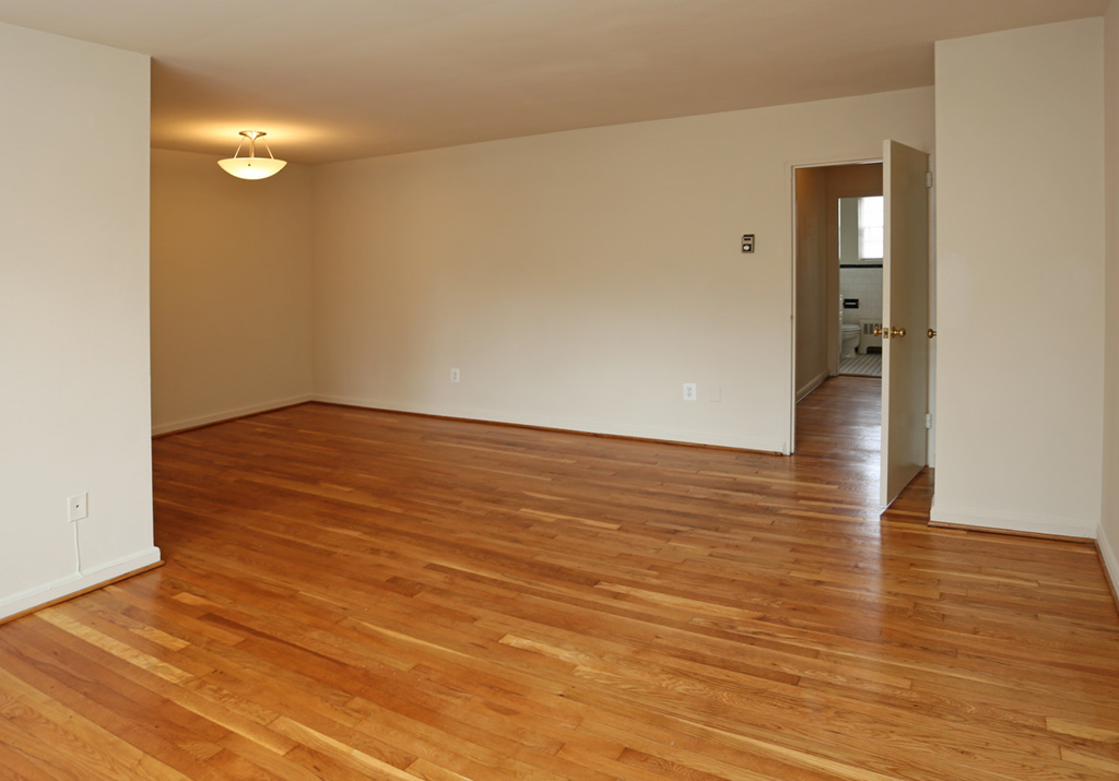 an empty living room with a hard wood floor
