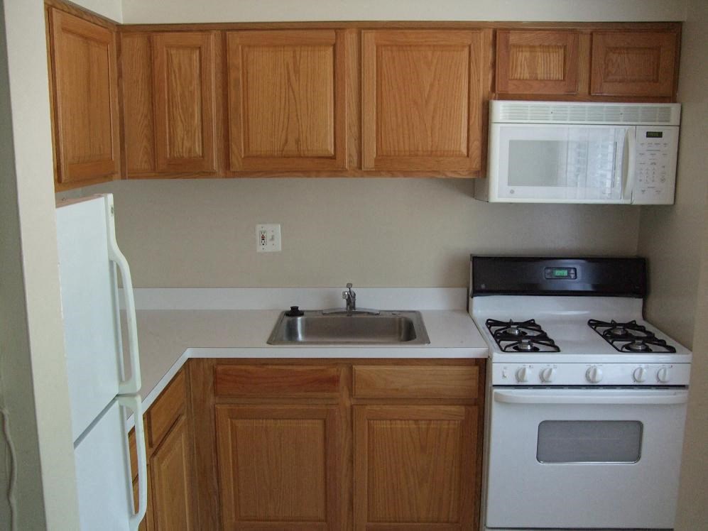 a kitchen with white appliances and wooden cabinets