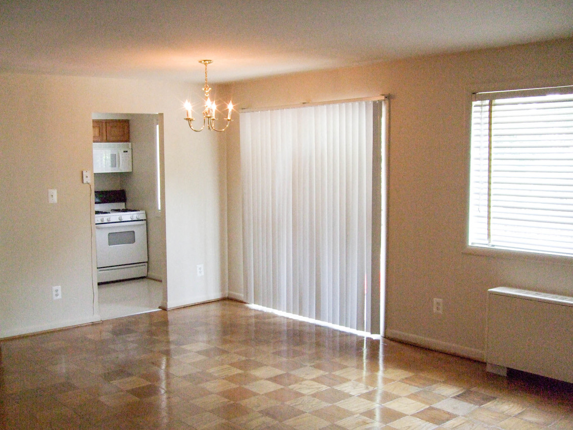 an empty living room and kitchen with a sliding glass door