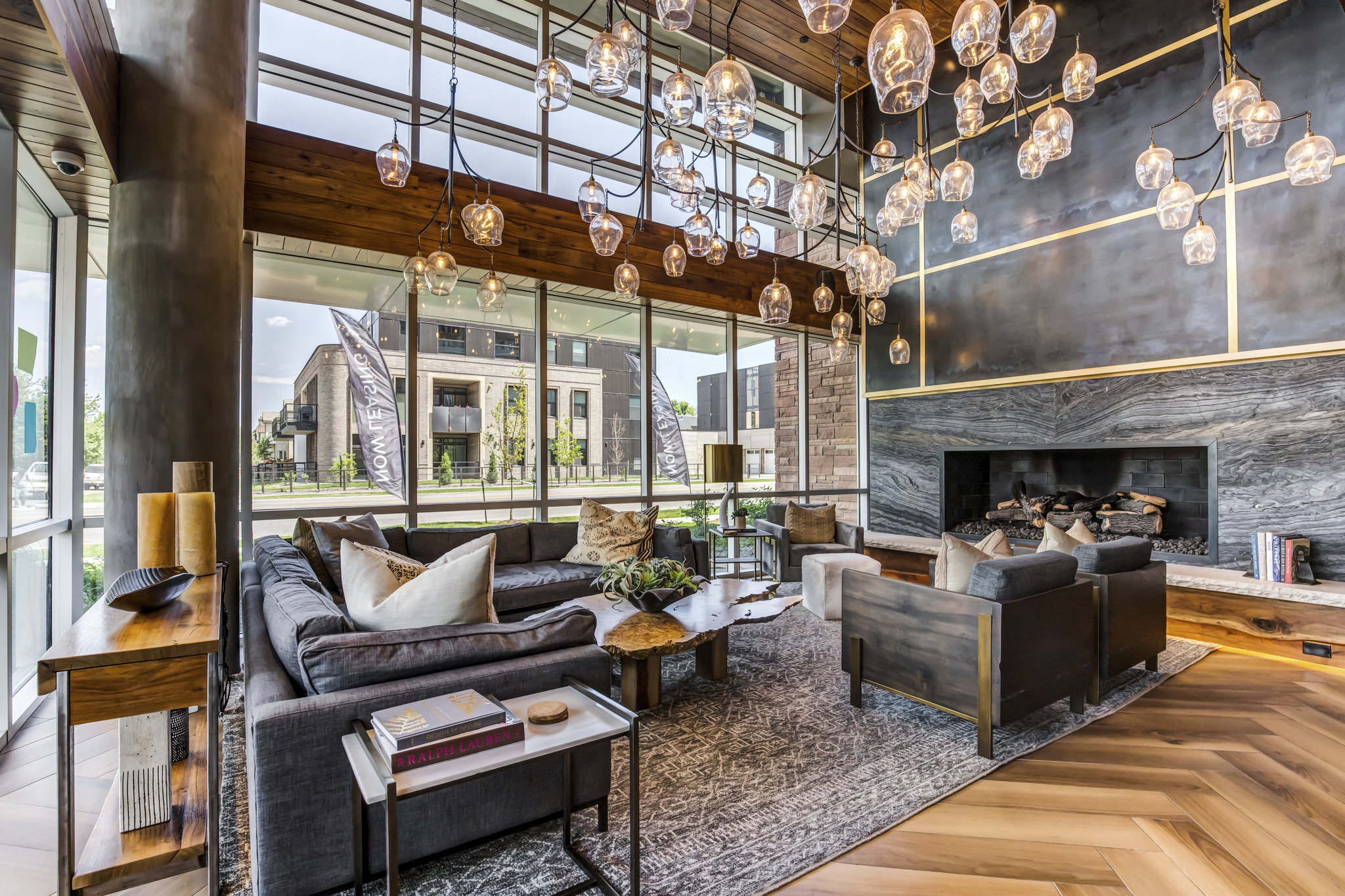 a living room with couches and a fireplace and large windows