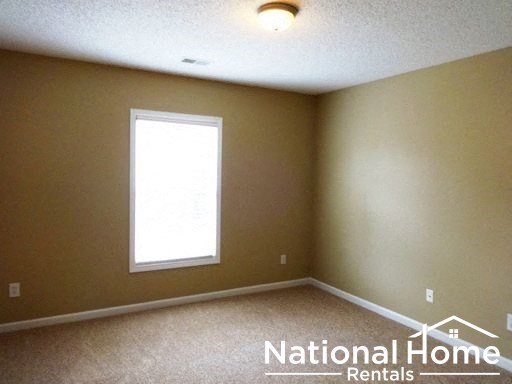 an empty room with a window and a ceiling light