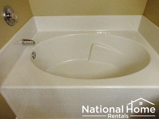 a white tub in a bathroom with the words national home rentals