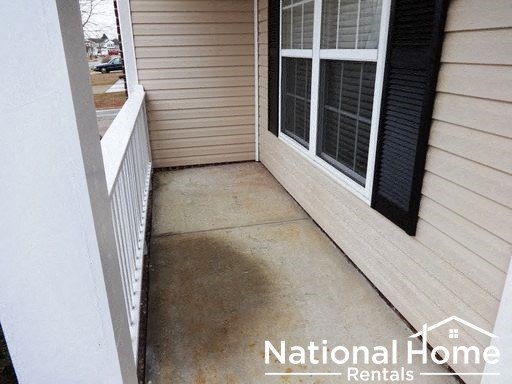 a dirty porch with a white house and a window