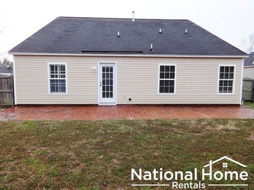 a home with a brick patio and a yard