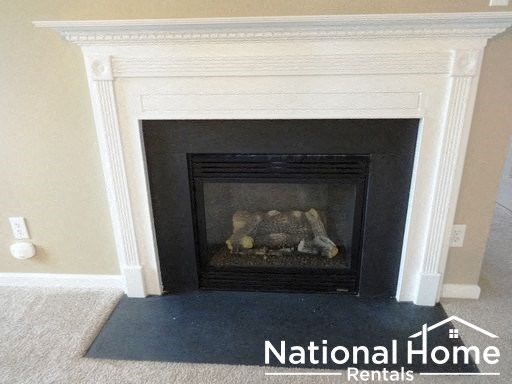 a fireplace in a room with a carpet and a fireplace