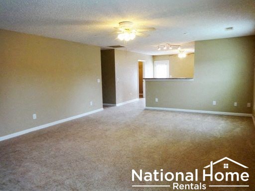 an empty living room and a kitchen in a house
