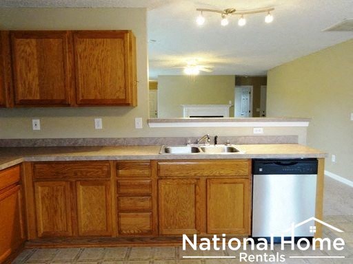 a kitchen with wooden cabinets and a white dishwasher