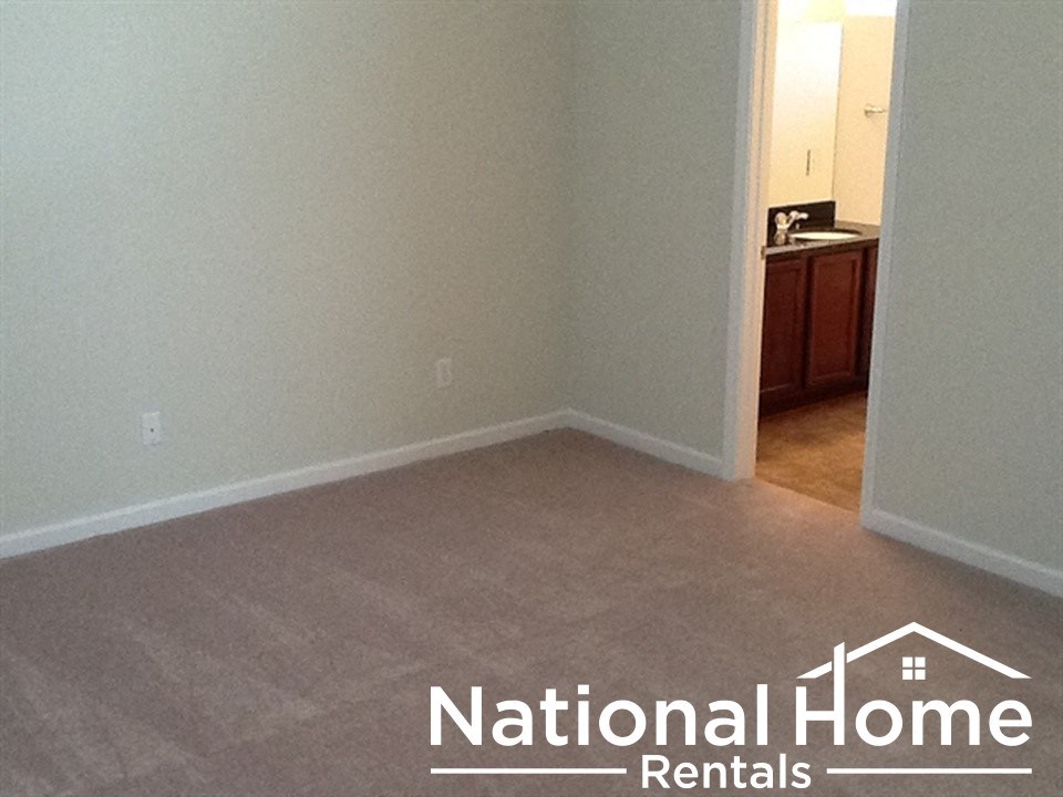 A room with a carpeted floor and a doorway leading to another room.