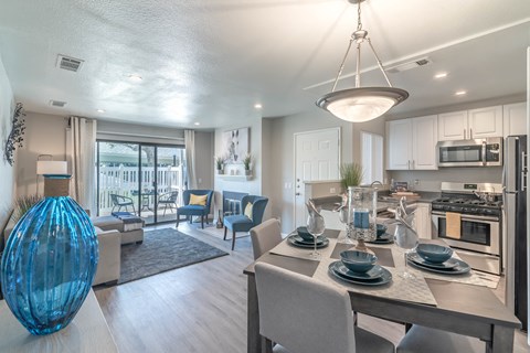 A modern kitchen with a dining table set for two.