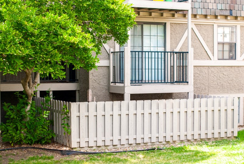 a white fence in front of an apartment building