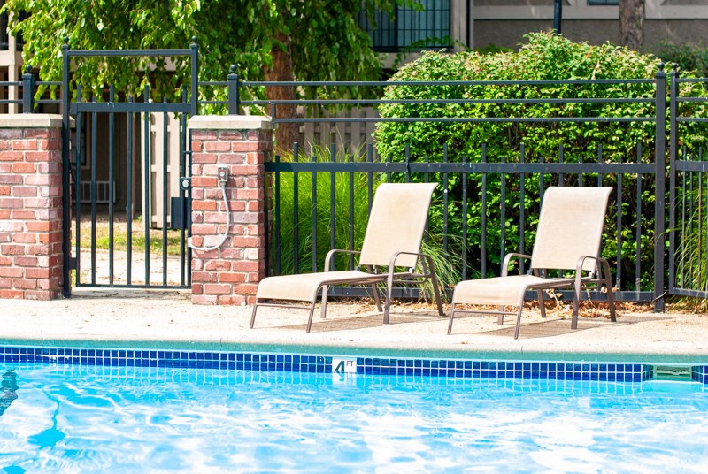 two lounge chairs next to a swimming pool
