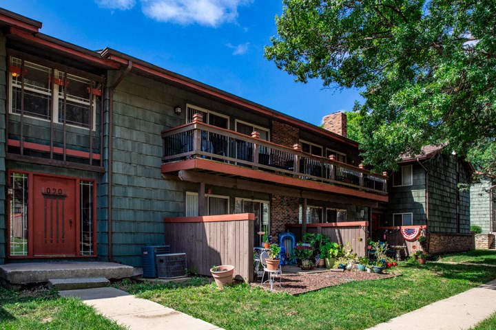 the front of a house with a yard and a tree