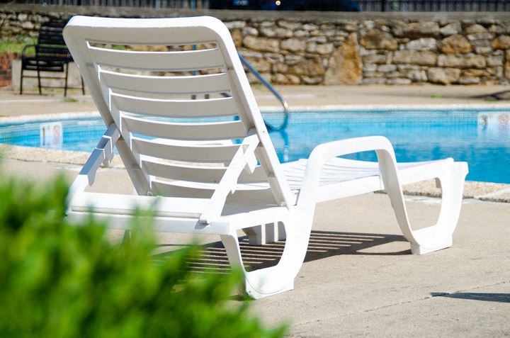 a white beach chair sitting next to a pool