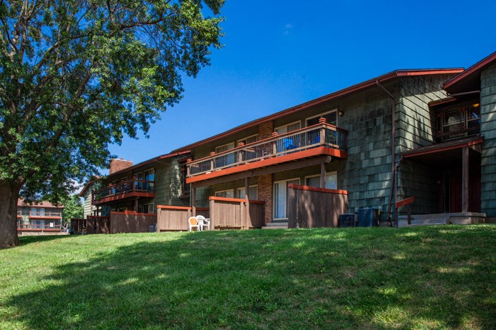 a view of the exterior of a building with grass and trees