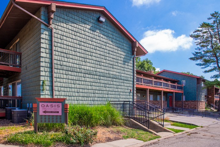 a green building with a sign in front of it