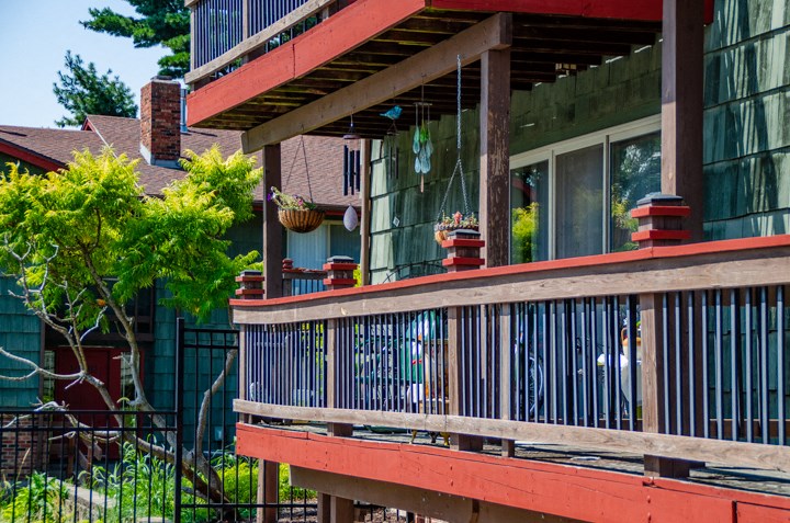 a house with a balcony and a fence and plants on it