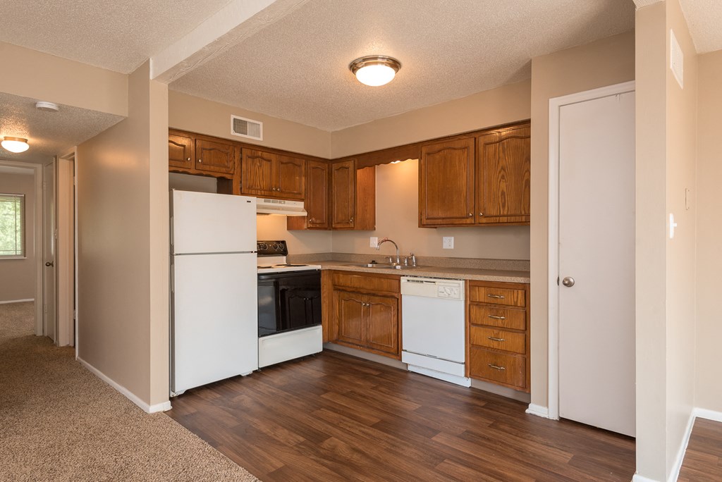 a kitchen with white appliances and wooden cabinets