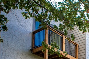a row of apartment buildings with balconies and a sidewalk