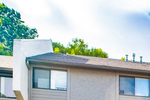 the front of an apartment building with a sidewalk and grass